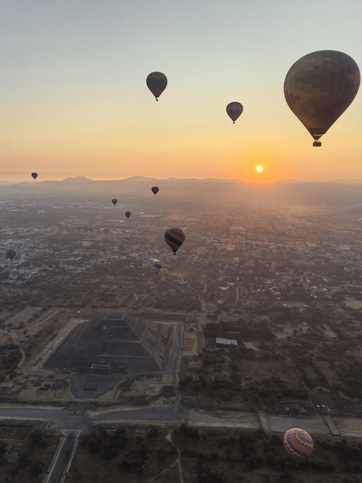 Hot air balloons spread across the sky over Teotihuacan