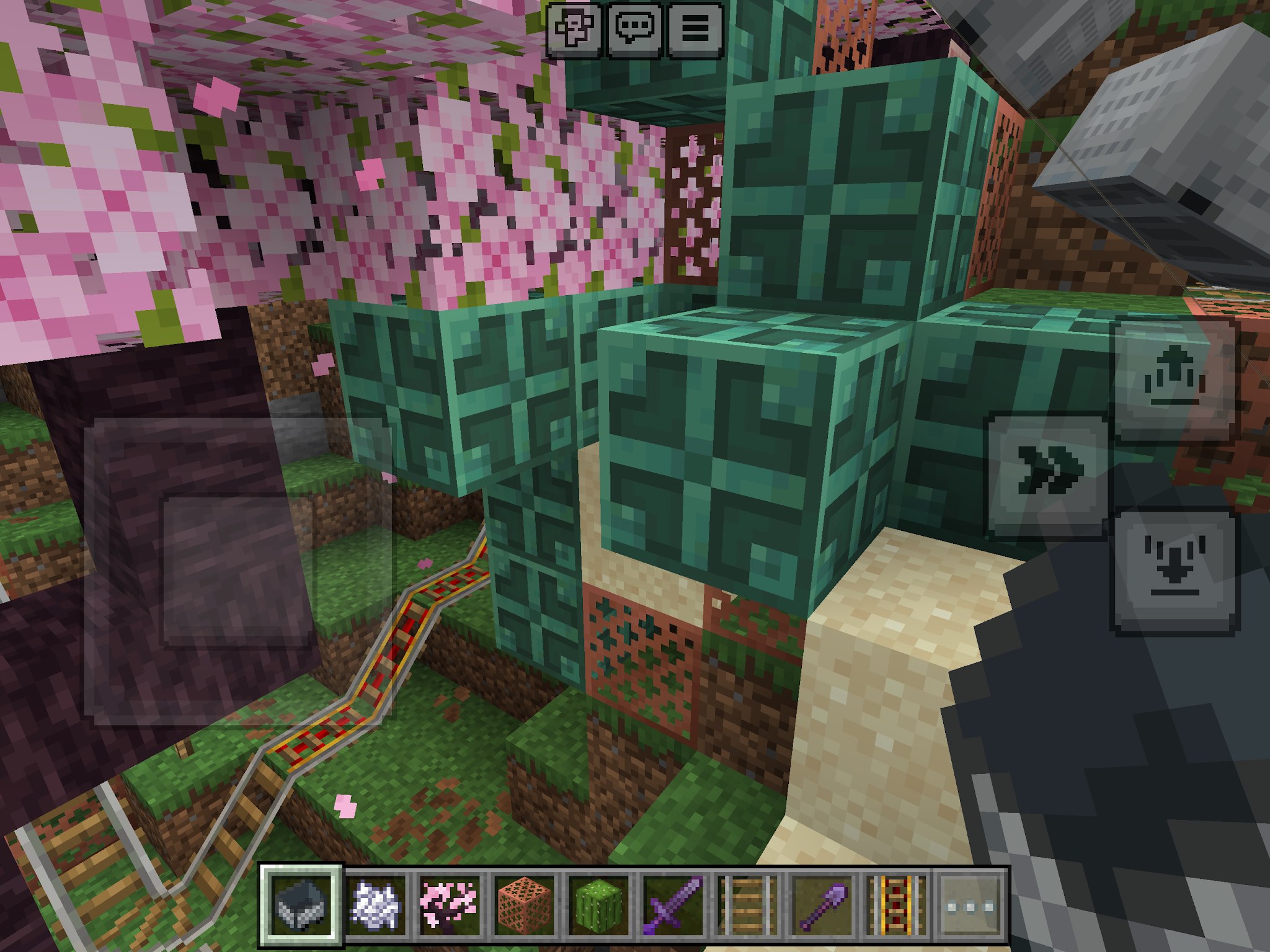 Minecraft rollercoaster track near cherry trees and decorated blocks